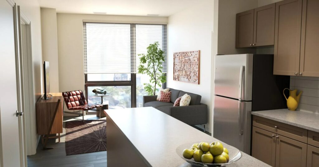 Light-filled apartment kitchen and living area with large windows, an indoor plant and modern furnishings.