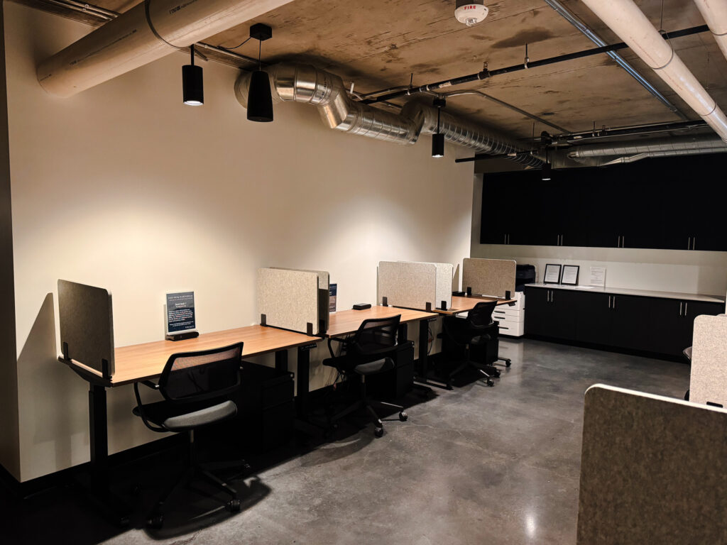 Individual workstations in Kenect Phoenix's coworking area, offering a quiet and functional environment with ergonomic chairs, dividers for privacy and a sleek industrial aesthetic.