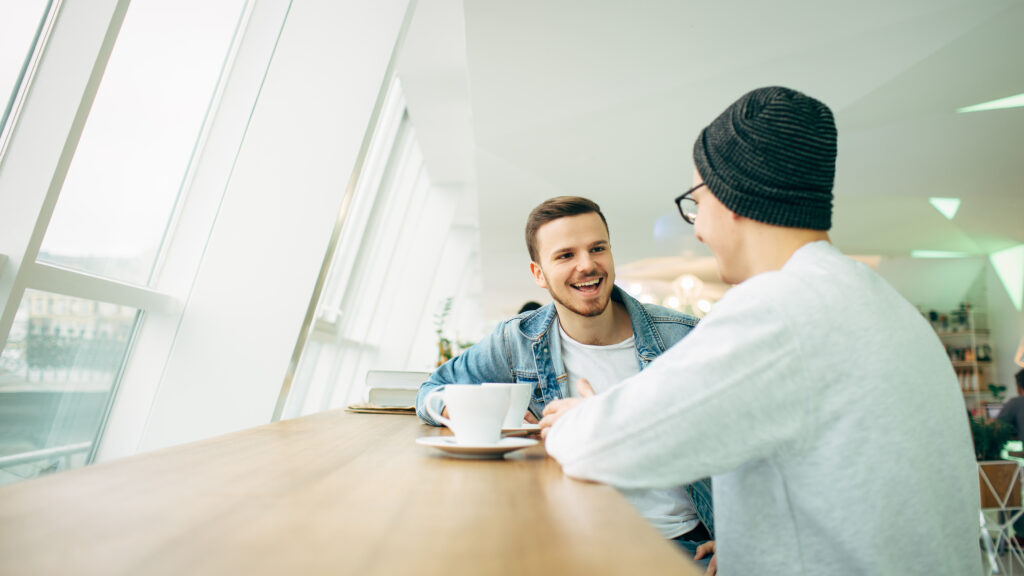 Two male potential roommates meet at a coffee shop to discuss living arrangements and get to know each other.